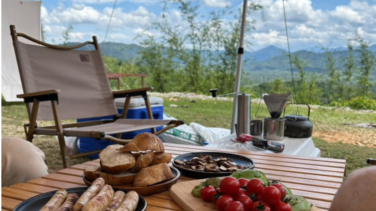 Food on Table With a Camping Chair and Titiwangsa Range in the Background at Willow Tree Campsite